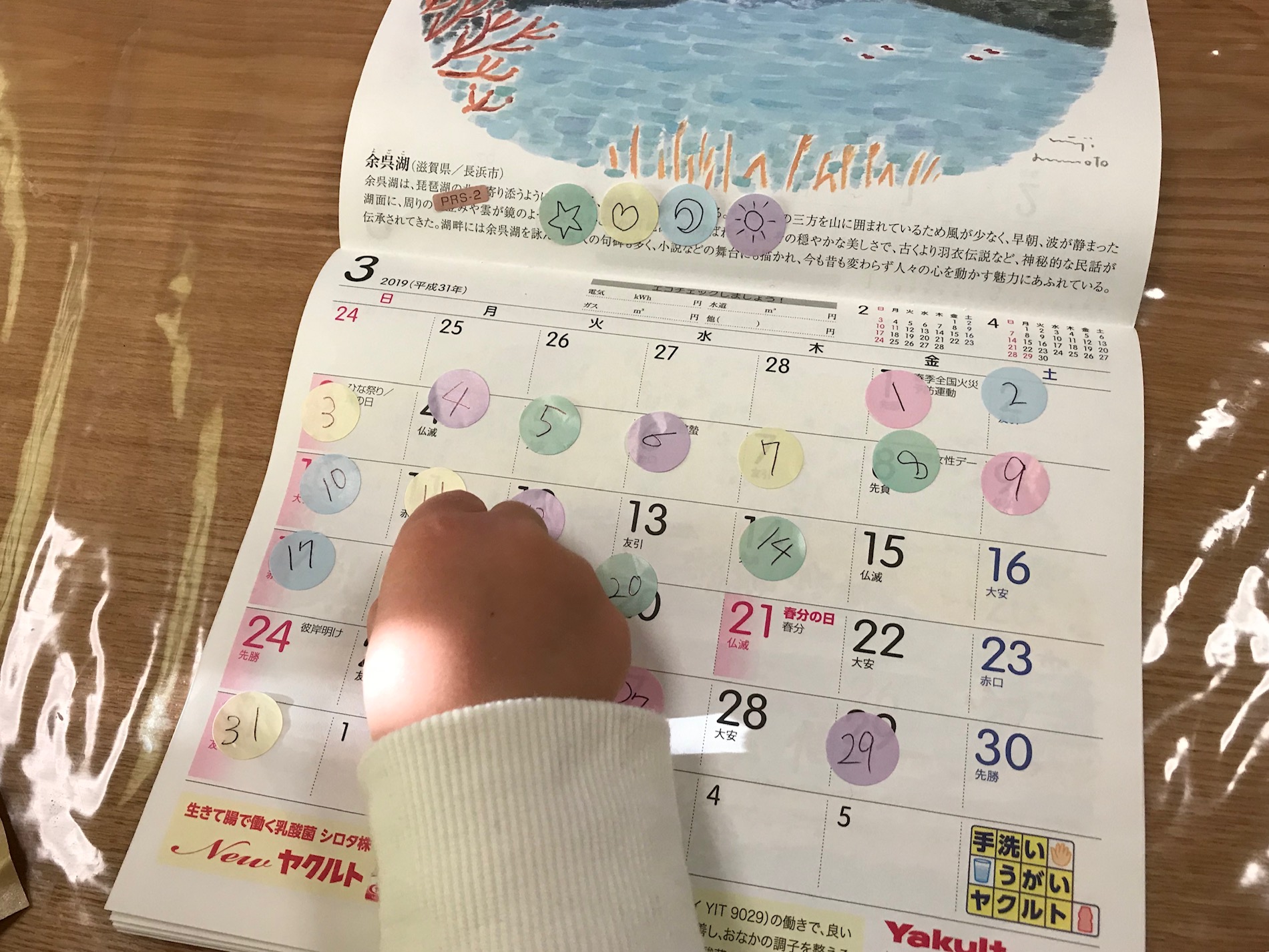 カレンダーに数字シールを貼る子どもの写真